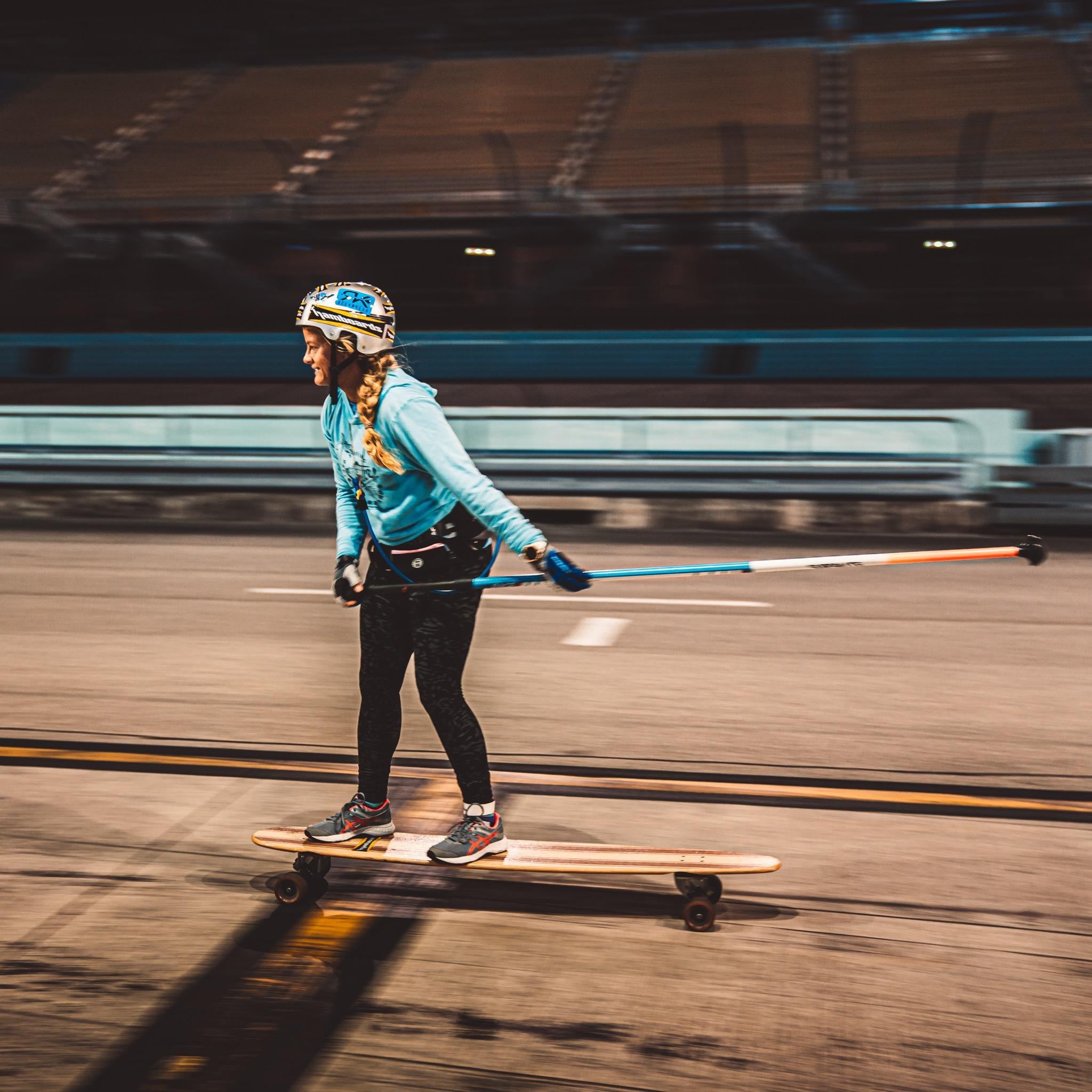 Person skating on a longboard in a sports arena.