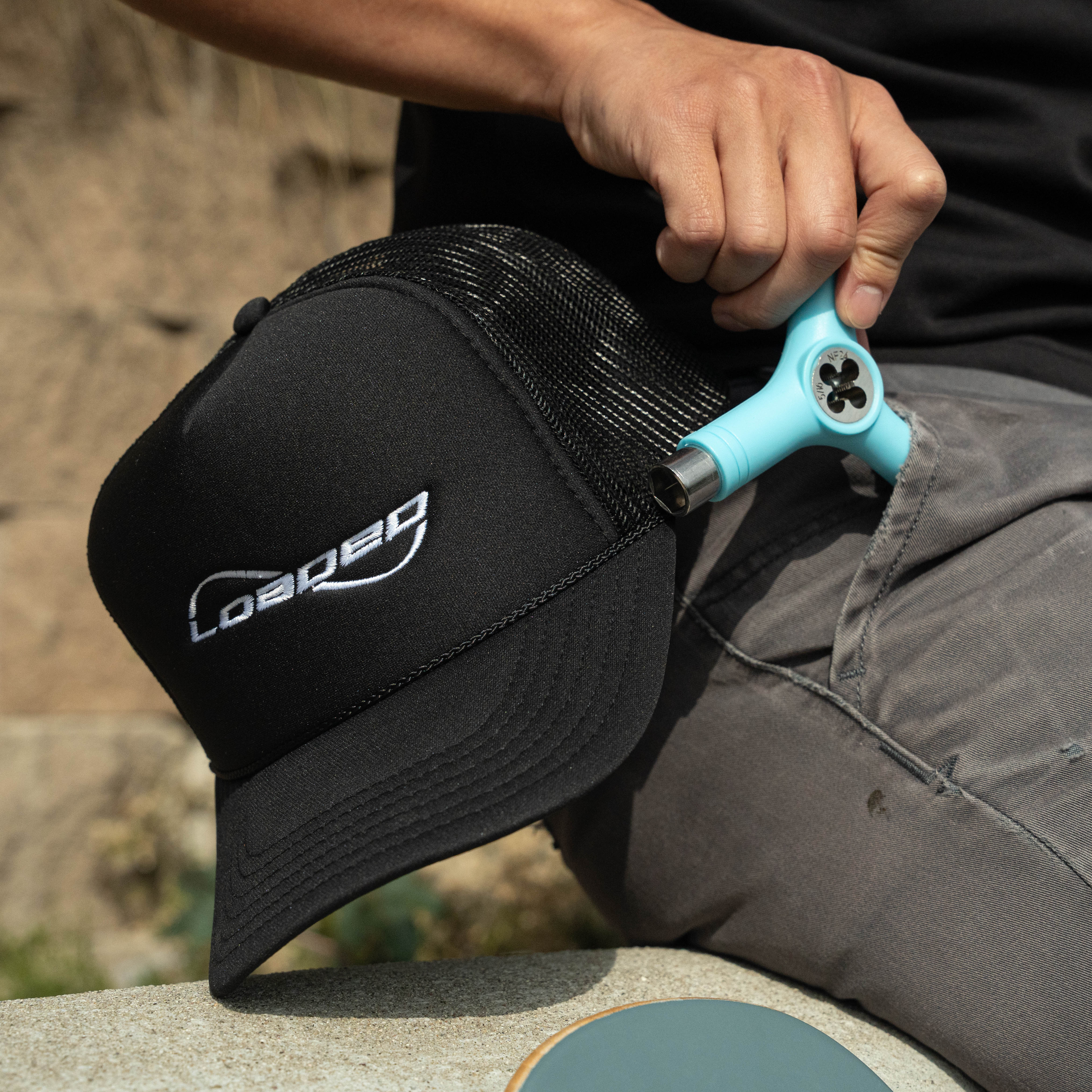 Person holding a black cap and a blue fidget toy.