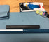 A surface with a ruler, a black cylindrical object, a cleaning brush, and a blue cloth.
