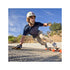 A skateboarder performing a trick on a downhill road with a focused expression.